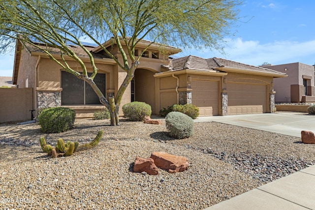 11413 S Coolwater Dr, Goodyear, AZ 85338 - view of front of property featuring stucco siding, driveway, stone siding, roof mounted solar panels, and a garage