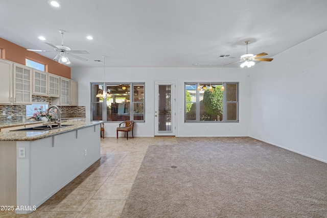 11413 S Coolwater Dr, Goodyear, AZ 85338 - kitchen with a sink, decorative backsplash, light stone counters, and ceiling fan