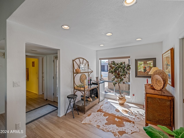 sitting room featuring a textured ceiling and light wood-type flooring