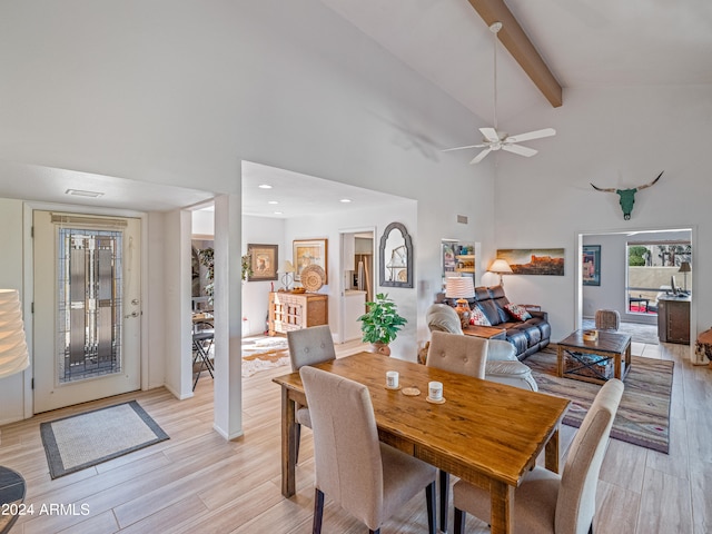 dining space with high vaulted ceiling, light hardwood / wood-style floors, ceiling fan, and beamed ceiling