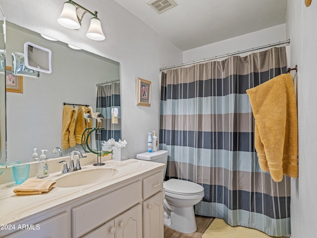 bathroom with wood-type flooring, toilet, and vanity with extensive cabinet space