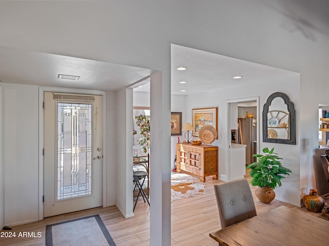 foyer with a textured ceiling and light hardwood / wood-style floors