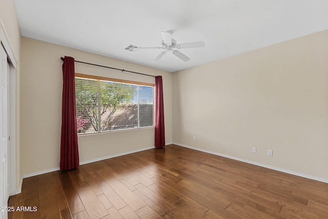 interior space featuring dark wood-style floors, baseboards, visible vents, and a ceiling fan