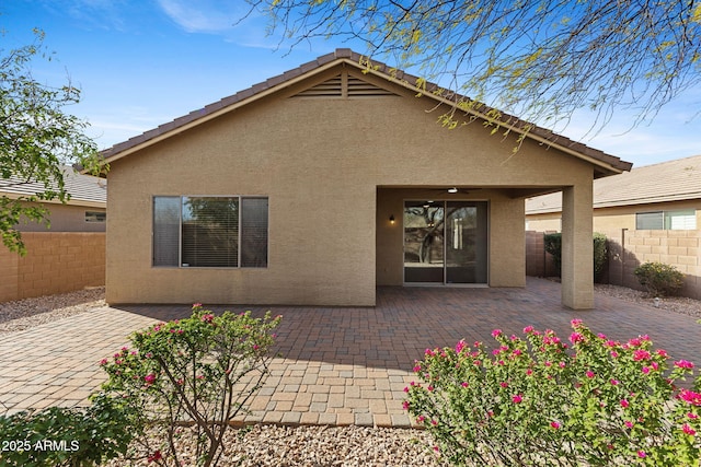 rear view of house with a patio area, a fenced backyard, and stucco siding