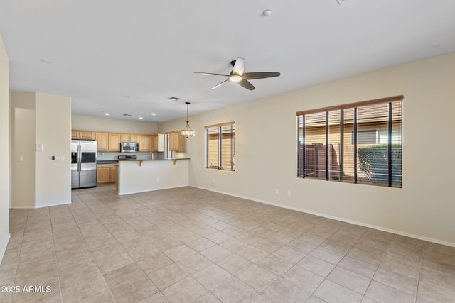 unfurnished living room with recessed lighting, light tile patterned floors, baseboards, and ceiling fan with notable chandelier