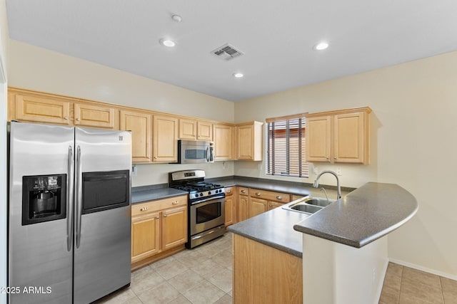 kitchen featuring stainless steel appliances, a peninsula, a sink, visible vents, and dark countertops