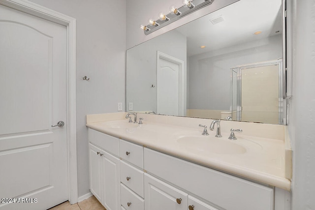 bathroom featuring tile patterned flooring, an enclosed shower, and vanity