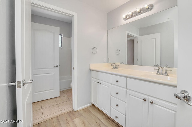 bathroom featuring a bathtub, hardwood / wood-style flooring, vanity, and toilet