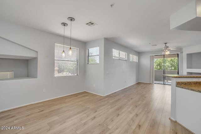 unfurnished living room with ceiling fan, light wood-type flooring, and plenty of natural light