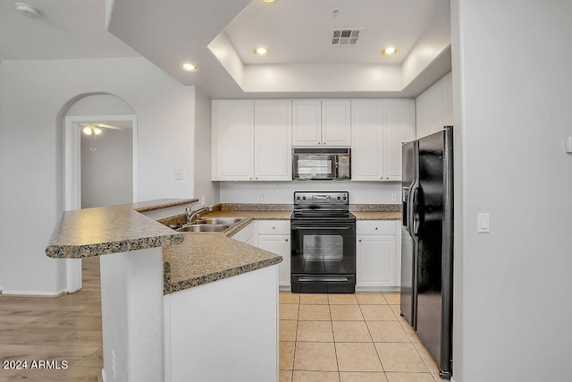 kitchen featuring white cabinets, sink, kitchen peninsula, black appliances, and light wood-type flooring