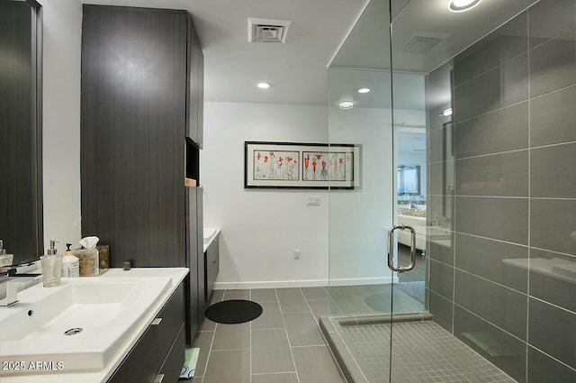 bathroom with tile patterned flooring, vanity, and walk in shower