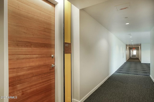 corridor with baseboards, dark carpet, and recessed lighting