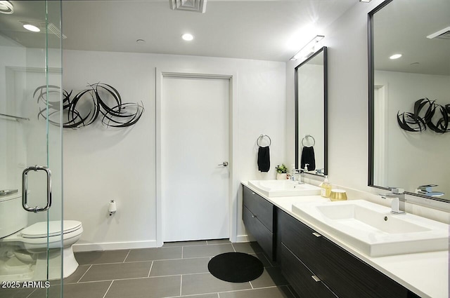 bathroom featuring tile patterned flooring, vanity, toilet, and a shower with door