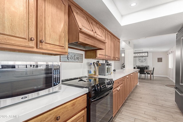 kitchen featuring custom range hood, light hardwood / wood-style flooring, and black range with electric cooktop