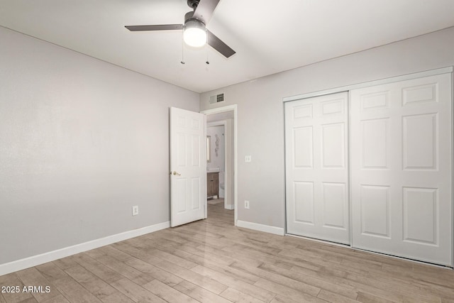 unfurnished bedroom featuring ceiling fan, light wood-type flooring, and a closet