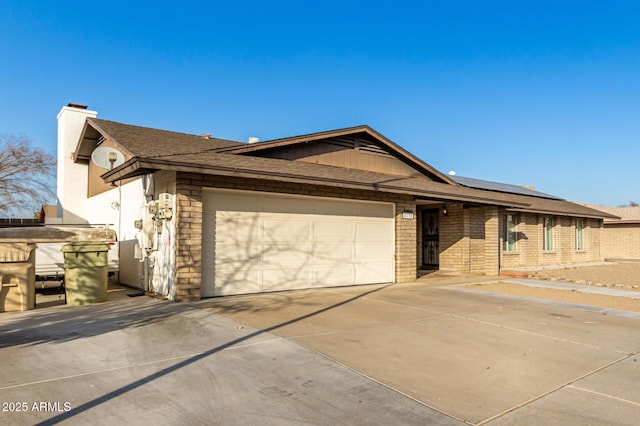 single story home featuring a garage and solar panels