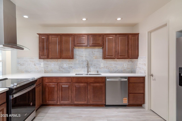 kitchen featuring appliances with stainless steel finishes, ventilation hood, a sink, and light countertops