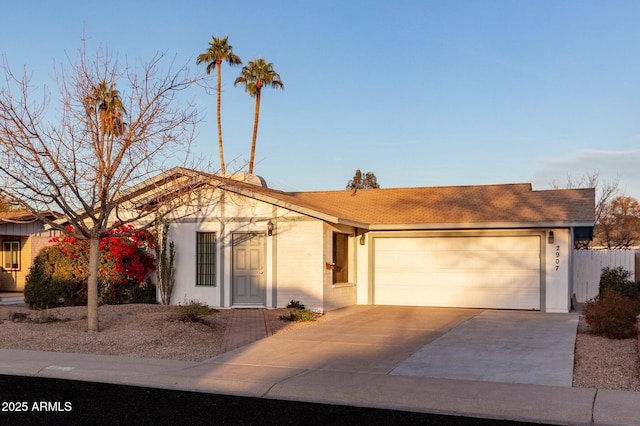 single story home featuring concrete driveway, an attached garage, and stucco siding