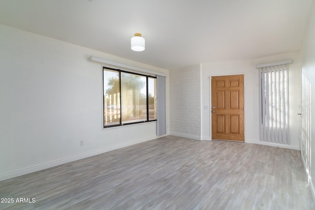 empty room featuring light wood finished floors and baseboards