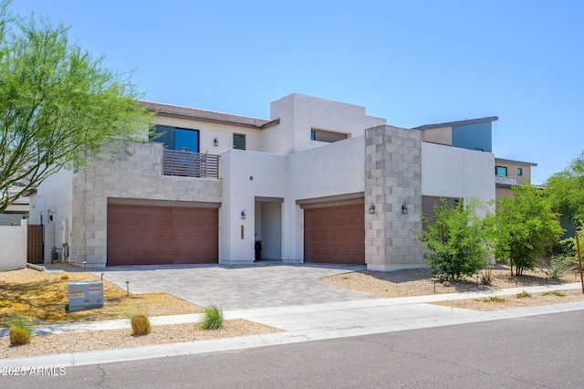 1221 E Paseo Way, Phoenix, AZ 85042 - contemporary house featuring a balcony, stucco siding, driveway, a garage, and stone siding