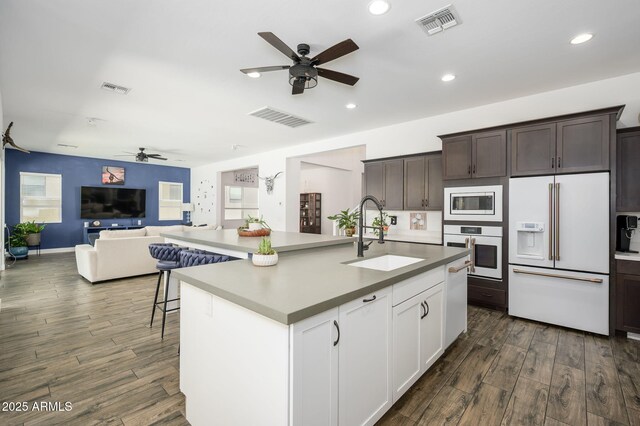 1221 E Paseo Way, Phoenix, AZ 85042 - kitchen with white appliances, a ceiling fan, a sink, dark wood-type flooring, and dark brown cabinetry