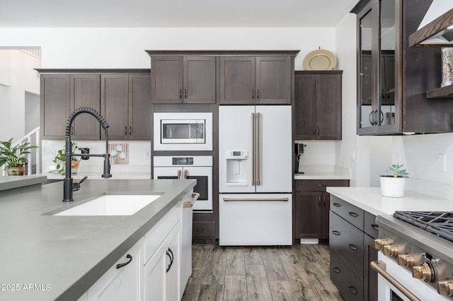 1221 E Paseo Way, Phoenix, AZ 85042 - kitchen with white appliances, a sink, dark brown cabinets, wood finished floors, and glass insert cabinets