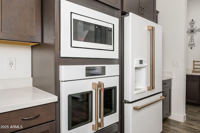 1221 E Paseo Way, Phoenix, AZ 85042 - kitchen with white appliances, dark brown cabinets, dark wood finished floors, and baseboards