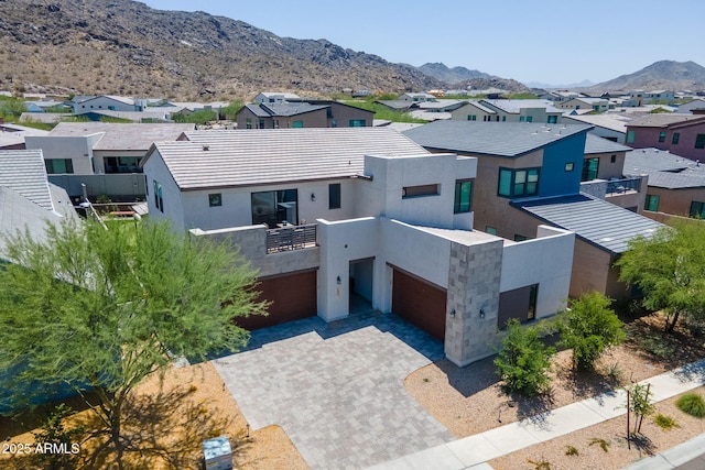 1221 E Paseo Way, Phoenix, AZ 85042 - modern home featuring a balcony, a residential view, a mountain view, stucco siding, and decorative driveway