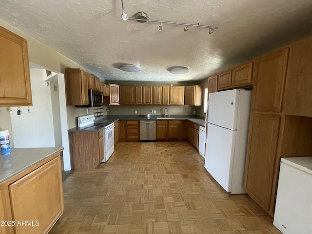1529 W Eva St, Phoenix, AZ 85021 - kitchen featuring brown cabinetry, a textured ceiling, rail lighting, a sink, and stainless steel appliances