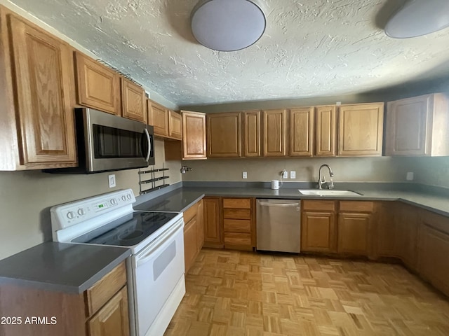 1529 W Eva St, Phoenix, AZ 85021 - kitchen featuring a sink, appliances with stainless steel finishes, brown cabinetry, and a textured ceiling