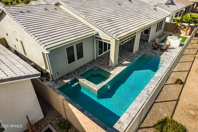 view of swimming pool with a patio area, a fenced backyard, and an in ground hot tub