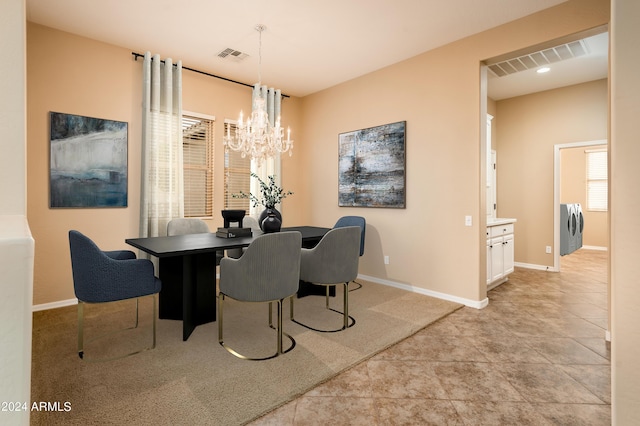 dining area with an inviting chandelier, washer / clothes dryer, and light tile patterned flooring