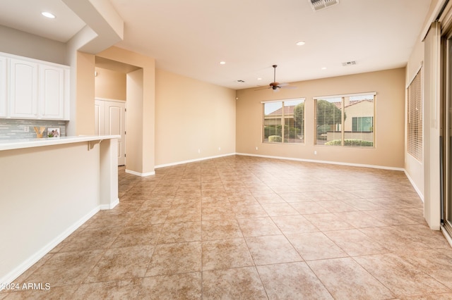 unfurnished living room featuring light tile patterned flooring and ceiling fan