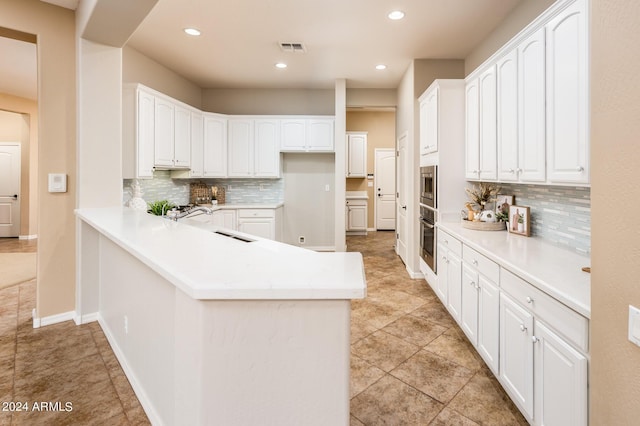 kitchen featuring white cabinetry, appliances with stainless steel finishes, and kitchen peninsula