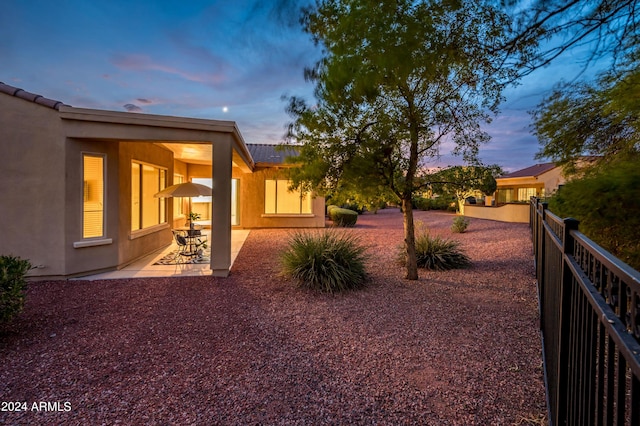 yard at dusk featuring a patio