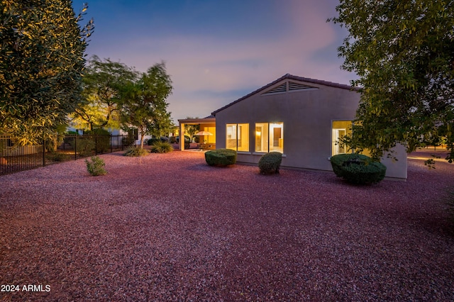 view of back house at dusk