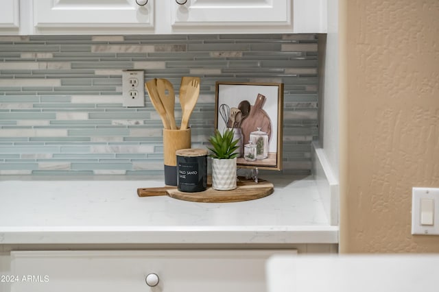 room details featuring white cabinetry and light stone countertops