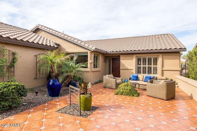 back of property with an outdoor living space and a patio