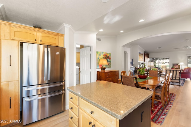 kitchen featuring stainless steel refrigerator, a center island, light hardwood / wood-style floors, and light brown cabinets