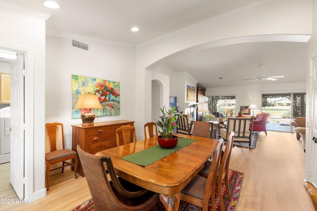 dining room featuring crown molding, ceiling fan, washer / clothes dryer, and light wood-type flooring