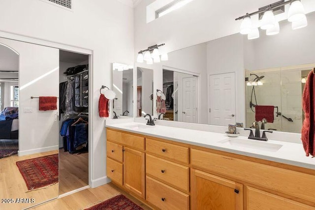 bathroom featuring vanity, a towering ceiling, hardwood / wood-style floors, and walk in shower