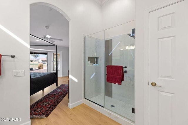 bathroom featuring hardwood / wood-style flooring, ceiling fan, and walk in shower