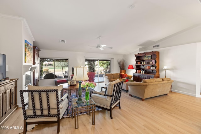 living room featuring lofted ceiling, light hardwood / wood-style flooring, ornamental molding, and ceiling fan