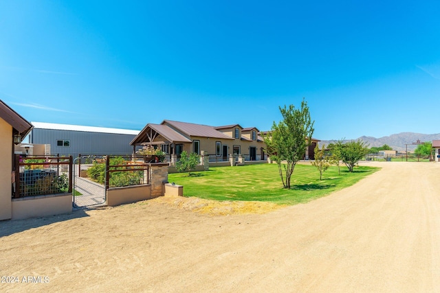 view of front of house with a front lawn, fence, and a mountain view