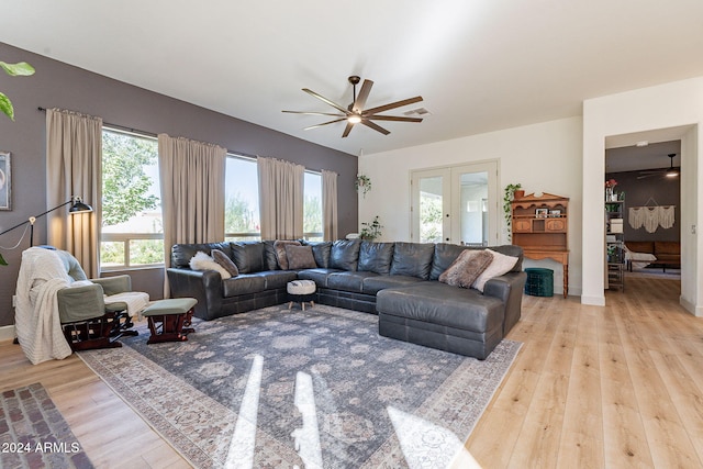 living room featuring french doors, light wood-type flooring, and ceiling fan