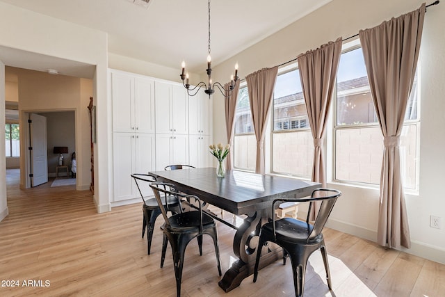 dining space featuring a healthy amount of sunlight, an inviting chandelier, and light wood-type flooring