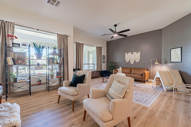 living room with light hardwood / wood-style floors and ceiling fan