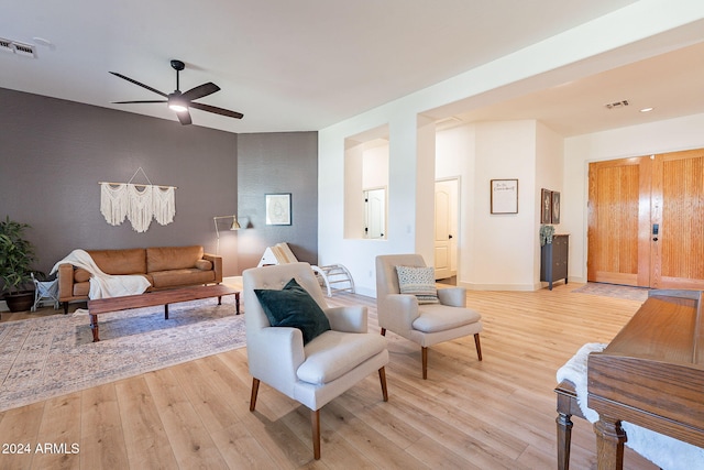 living room featuring light hardwood / wood-style flooring and ceiling fan