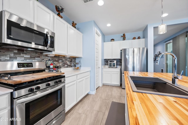 kitchen featuring white cabinetry, pendant lighting, stainless steel appliances, and sink