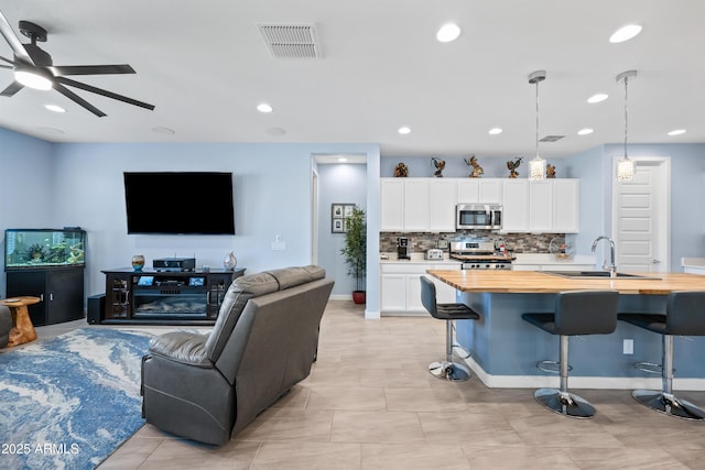 living room featuring ceiling fan and sink